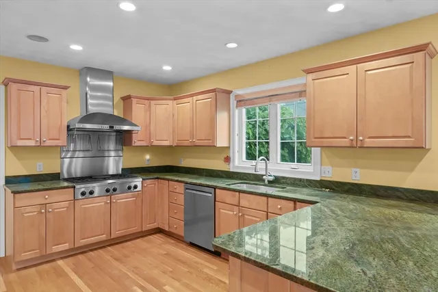 a kitchen with stainless steel appliances granite countertop a sink stove and cabinets