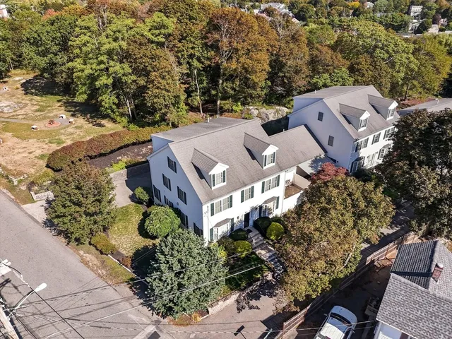 an aerial view of a house with a yard and trees