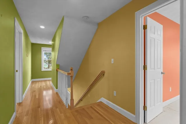 a view of a hallway with wooden floor and staircase