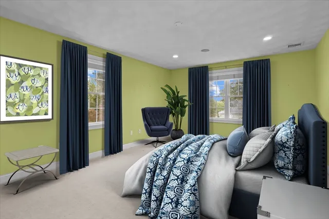 a bedroom with a bed and large windows