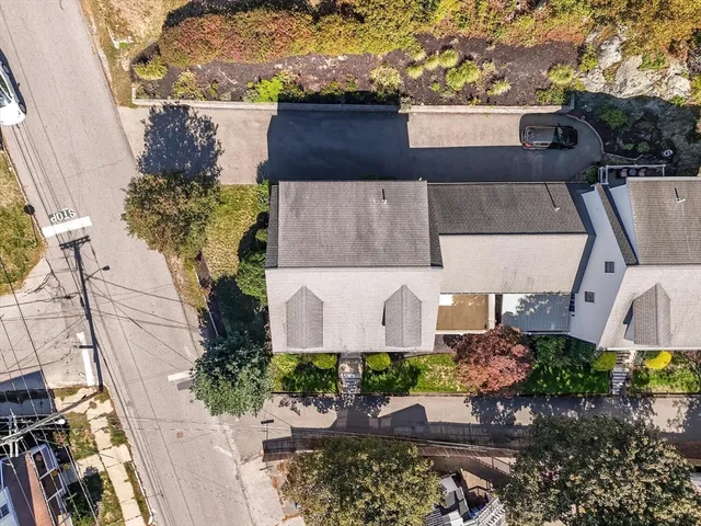 an aerial view of a house with a yard and a large tree