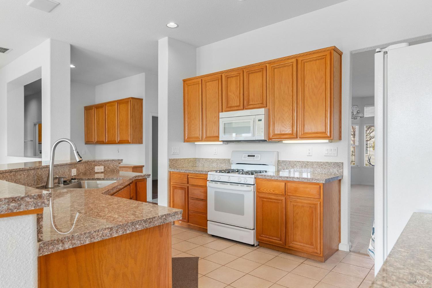 139 Cedar Ridge Drive Rio Vista, CA 94571 - Photo 8 of 52 Kitchen features a gas stove and oven, microwave, refrigerator, island with sink.