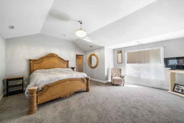 a bedroom with a bed and a chair with the view