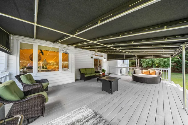 a living room with furniture fireplace and large windows