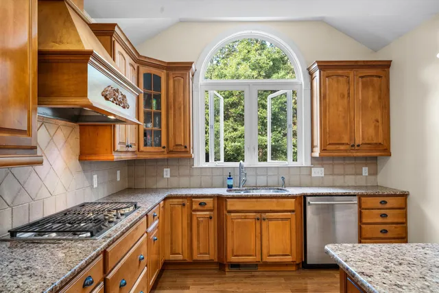 a kitchen with stainless steel appliances granite countertop a stove a sink and a microwave