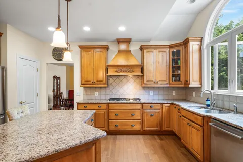 a kitchen with granite countertop a sink stainless steel appliances and cabinets