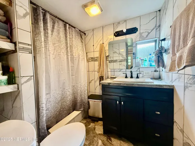 a bathroom with a sink a toilet and shower curtain