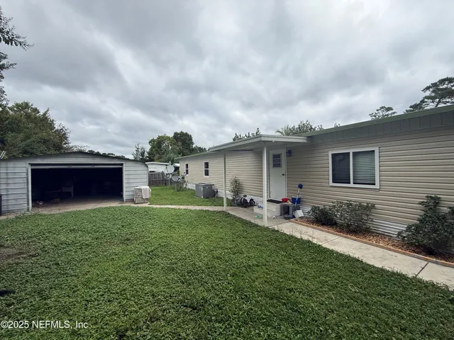 a backyard of a house with table and chairs