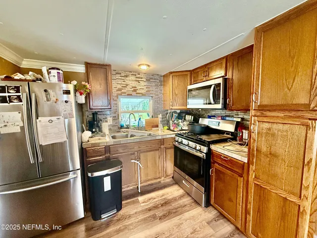 a kitchen with stainless steel appliances granite countertop a refrigerator stove and sink