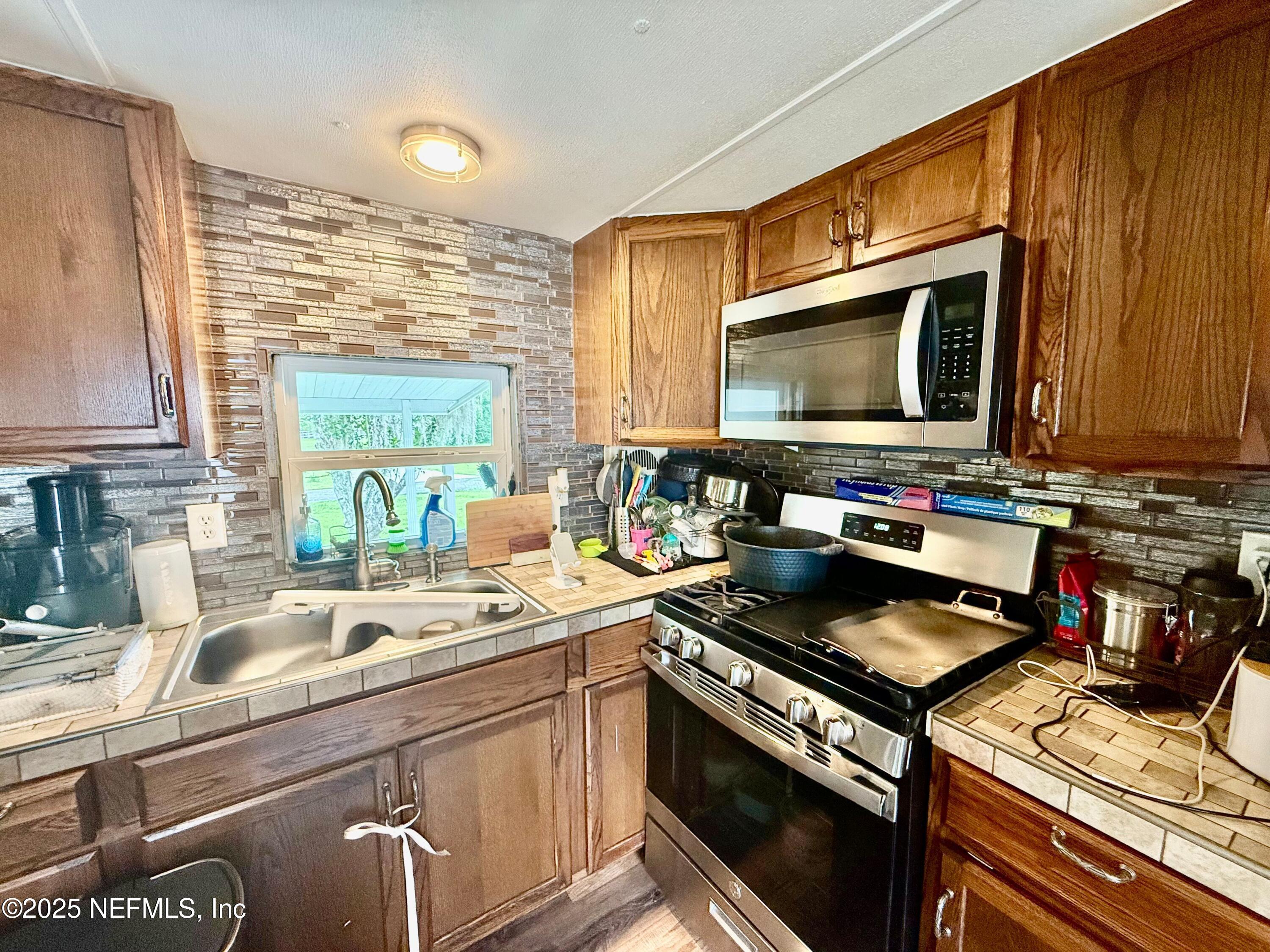 239 Pine Tree Trail Crescent City, FL 32112 - Photo 9 of 21 a kitchen with a stove and a sink