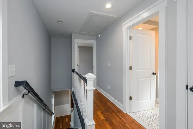 a view of a hallway with wooden floor and staircase