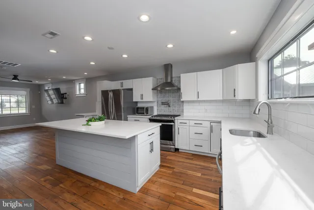 a kitchen with white cabinets stainless steel appliances and window