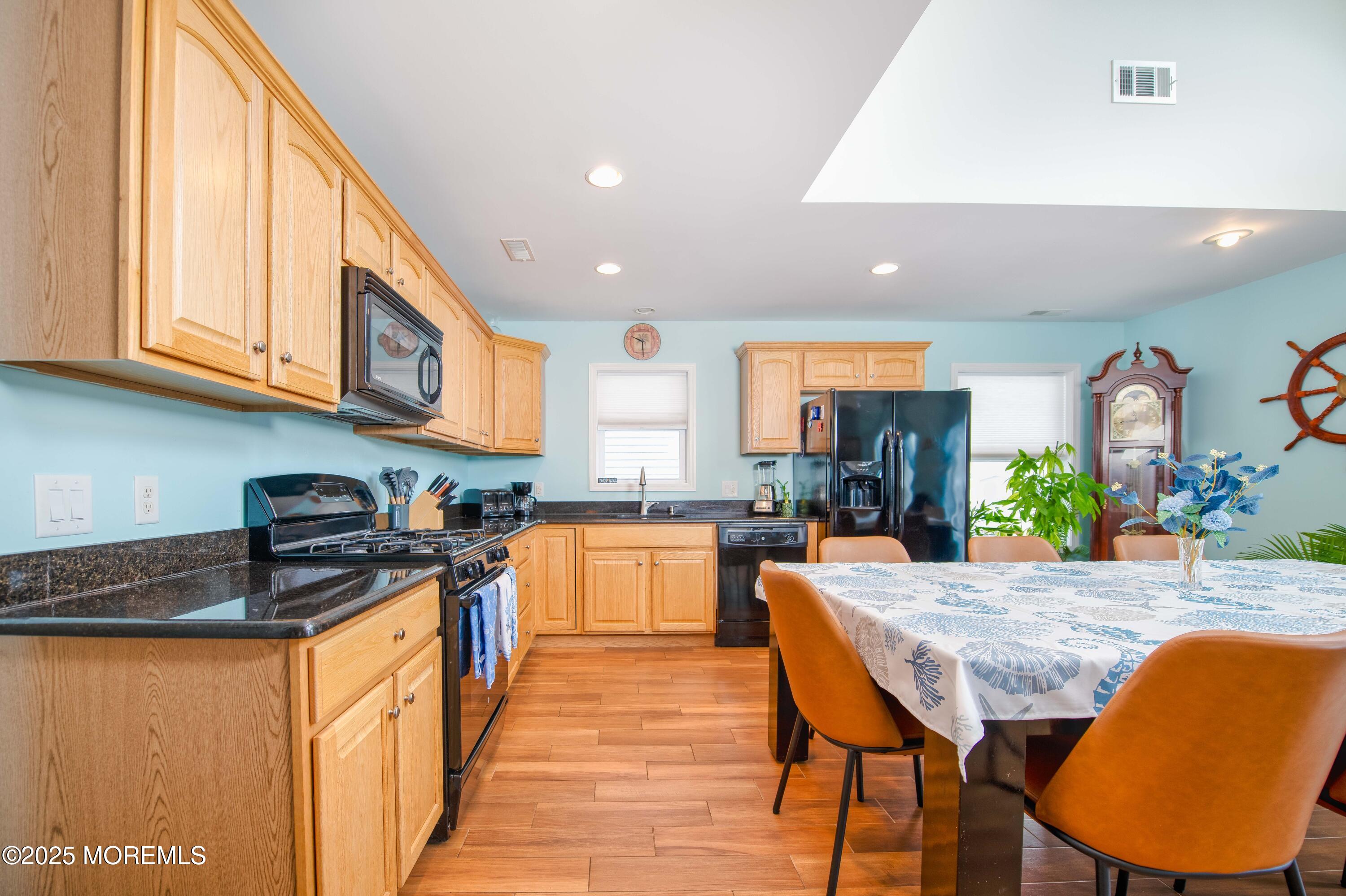 45 Sylvia Lane Manahawkin, NJ 08050 - Photo 11 of 36 a kitchen with stainless steel appliances granite countertop a stove a sink dishwasher and a refrigerator with wooden floor
