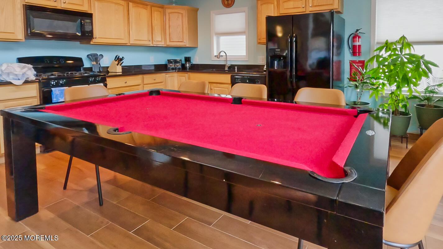 45 Sylvia Lane Manahawkin, NJ 08050 - Photo 13 of 36 a kitchen with stainless steel appliances kitchen island granite countertop a sink dishwasher and cabinets with wooden floor