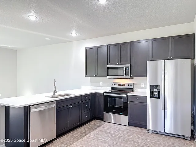 a view of a kitchen with a sink wooden floor and windows