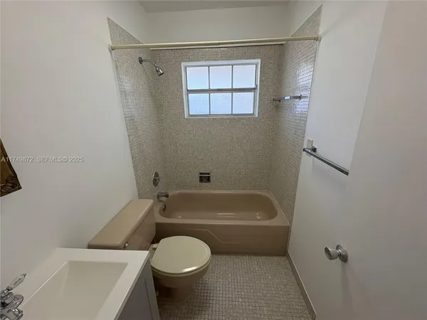 a bathroom with a toilet and white tub