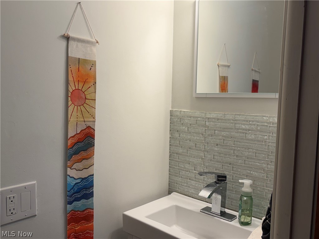 1604 Maplegrove Road South Euclid, OH 44121 - Photo 17 of 25 Modern vanity with an integrated rectangular sink, sleek chrome faucet, and a subway tile backsplash