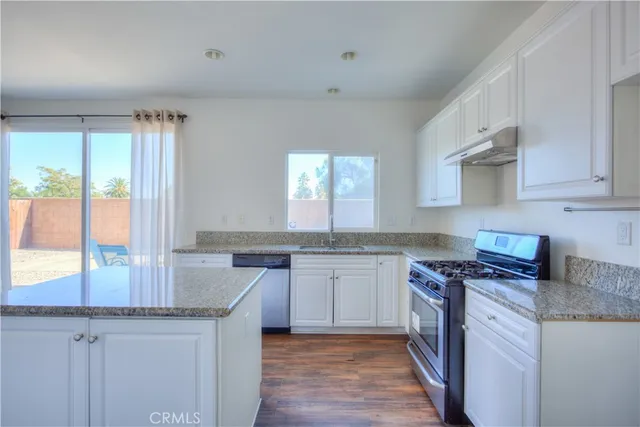 a kitchen with stainless steel appliances granite countertop a sink stove and cabinets