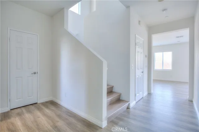a view of a hallway with wooden floor and entryway
