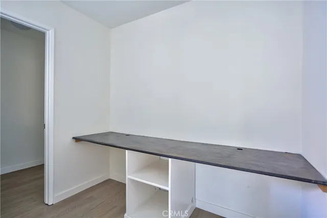an empty room with chandelier fan and windows