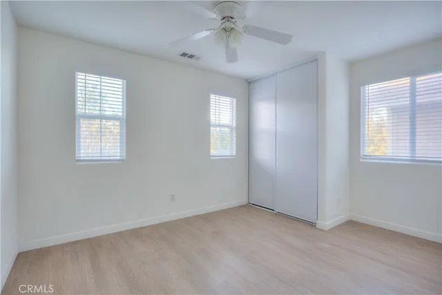 an empty room with windows and closet