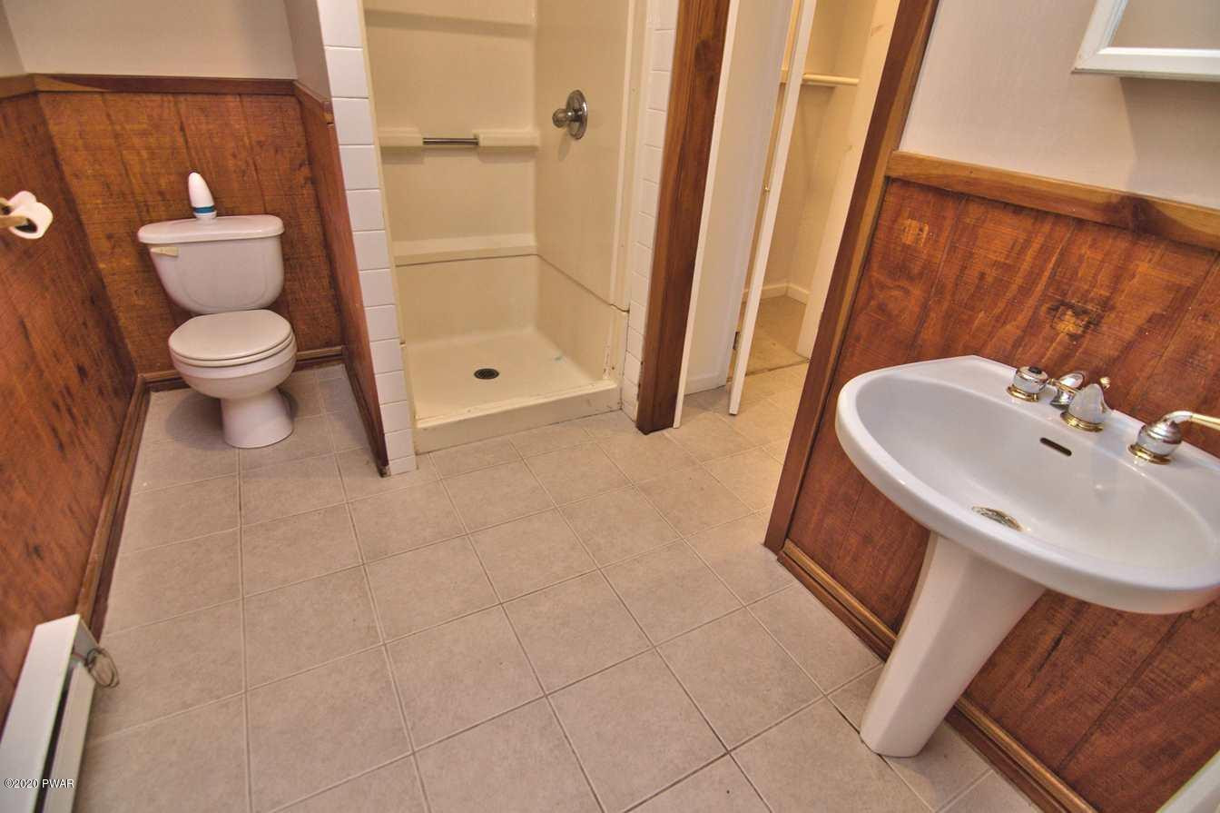 5690 Haas Pond Road Moscow, PA 18444 - Photo 59 of 79 a bathroom with a sink a toilet and shower