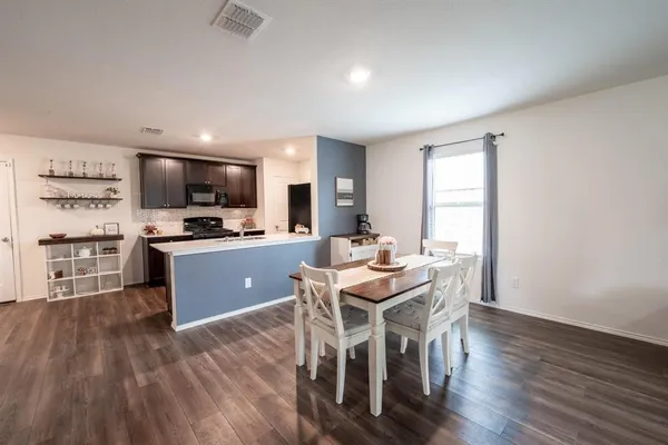 a kitchen with stainless steel appliances kitchen island granite countertop wooden floors and cabinets