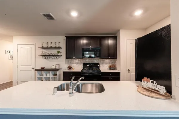 a kitchen with stainless steel appliances a stove a sink a microwave and refrigerator