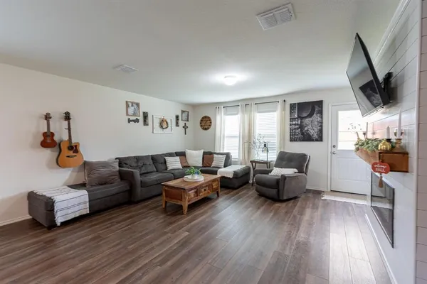 a living room with furniture or wooden floor and a flat screen tv