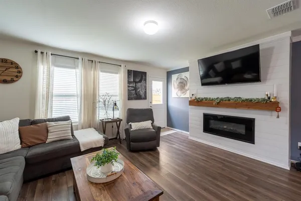 a living room with furniture a flat screen tv and a fireplace
