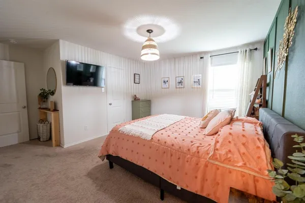 a bedroom with a bed and a flat screen tv