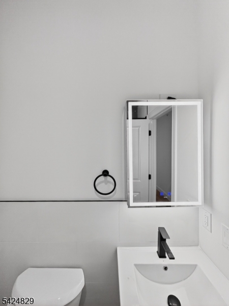 262 Hunterdon Street, Unit 1 Newark, NJ 07103 - Photo 24 of 31 a bathroom with a sink mirror vanity and toilet