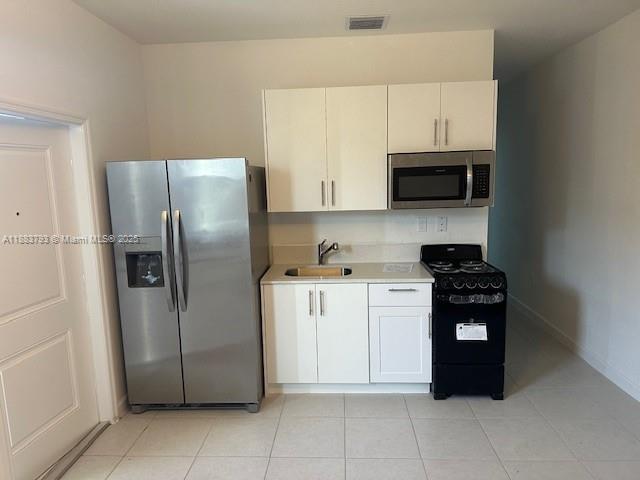 834 Southeast 26th Street, Unit STUDIO Homestead, FL 33035 - Photo 4 of 11 a kitchen with a refrigerator and a stove top oven