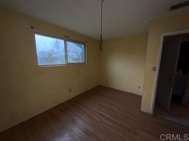 1366 Far Valley Road Campo, CA 91906 - Photo 10 of 26 a view of an empty room with wooden floor and a window