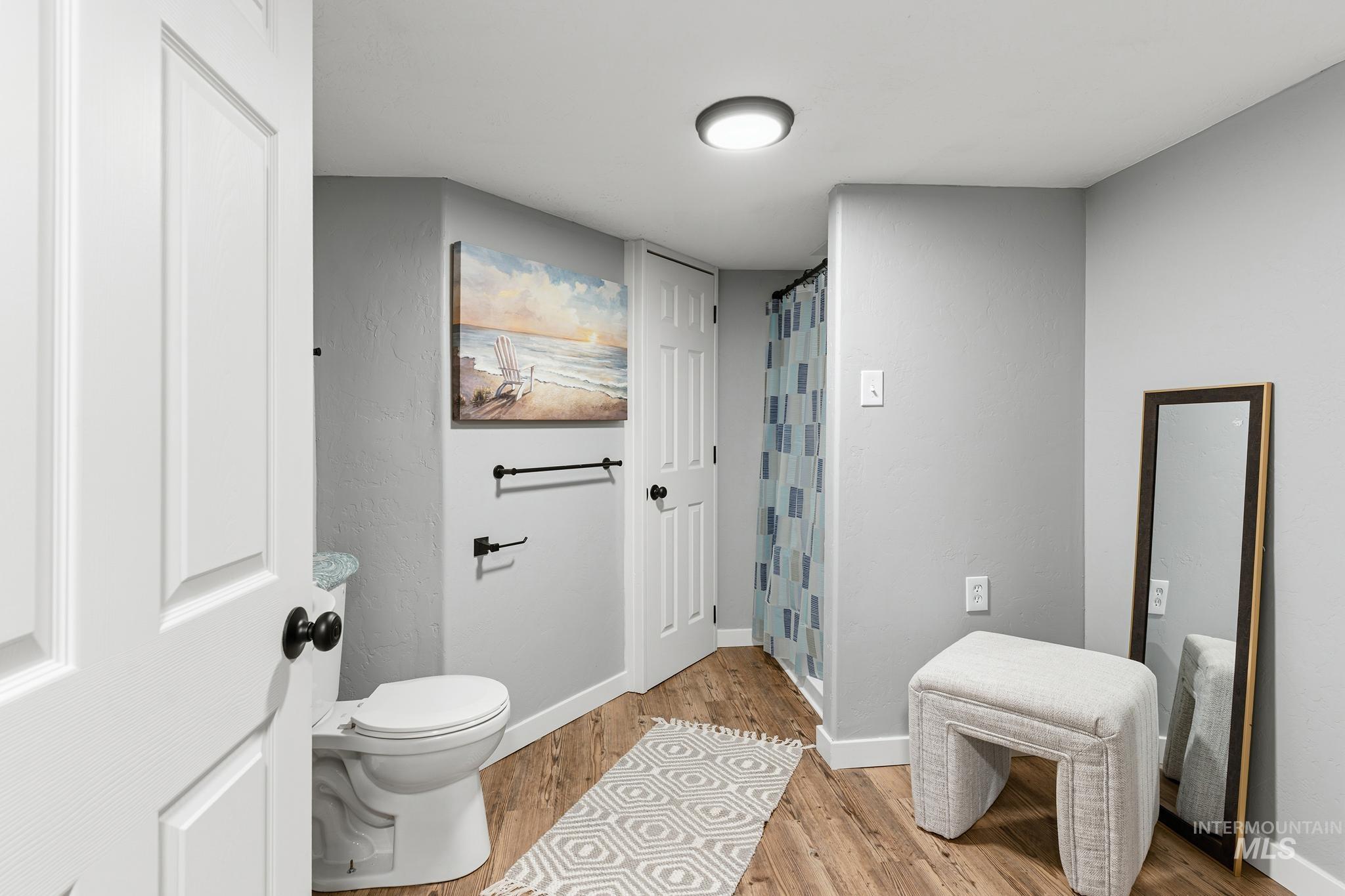 619 Thain Road Lewiston, ID 83501 - Photo 11 of 44 Bathroom featuring wood-finish flooring, a white toilet, recessed lighting, and a shower with a patterned curtain