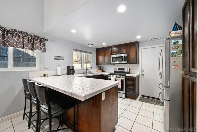 a kitchen with a stove a refrigerator and a dining table