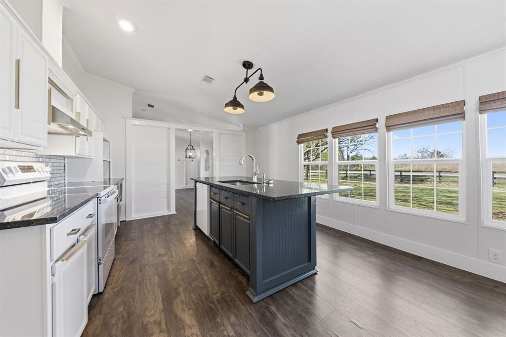 734 Northfork Road Royse City, TX 75189 - Photo 11 of 35 a kitchen with granite countertop a stove top oven a sink dishwasher and wooden cabinets with wooden floor