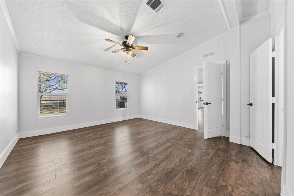 734 Northfork Road Royse City, TX 75189 - Photo 17 of 35 an empty room with wooden floor chandelier fan and windows