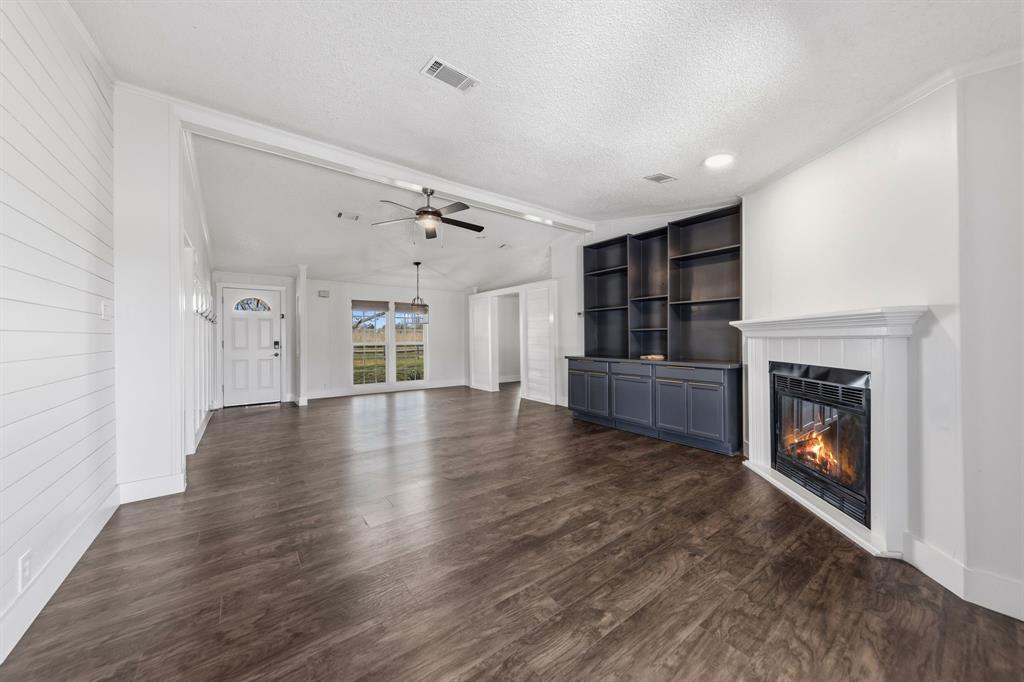 734 Northfork Road Royse City, TX 75189 - Photo 8 of 35 a view of an empty room with fireplace and wooden floor