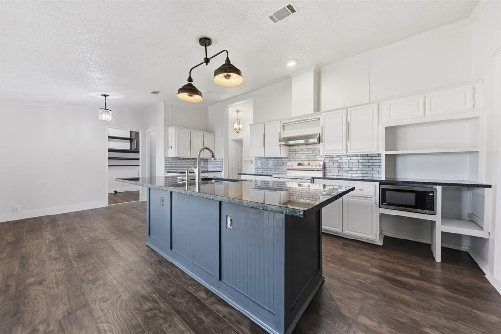 734 Northfork Road Royse City, TX 75189 - Photo 9 of 35 a kitchen with kitchen island stainless steel appliances a sink cabinets and wooden floor