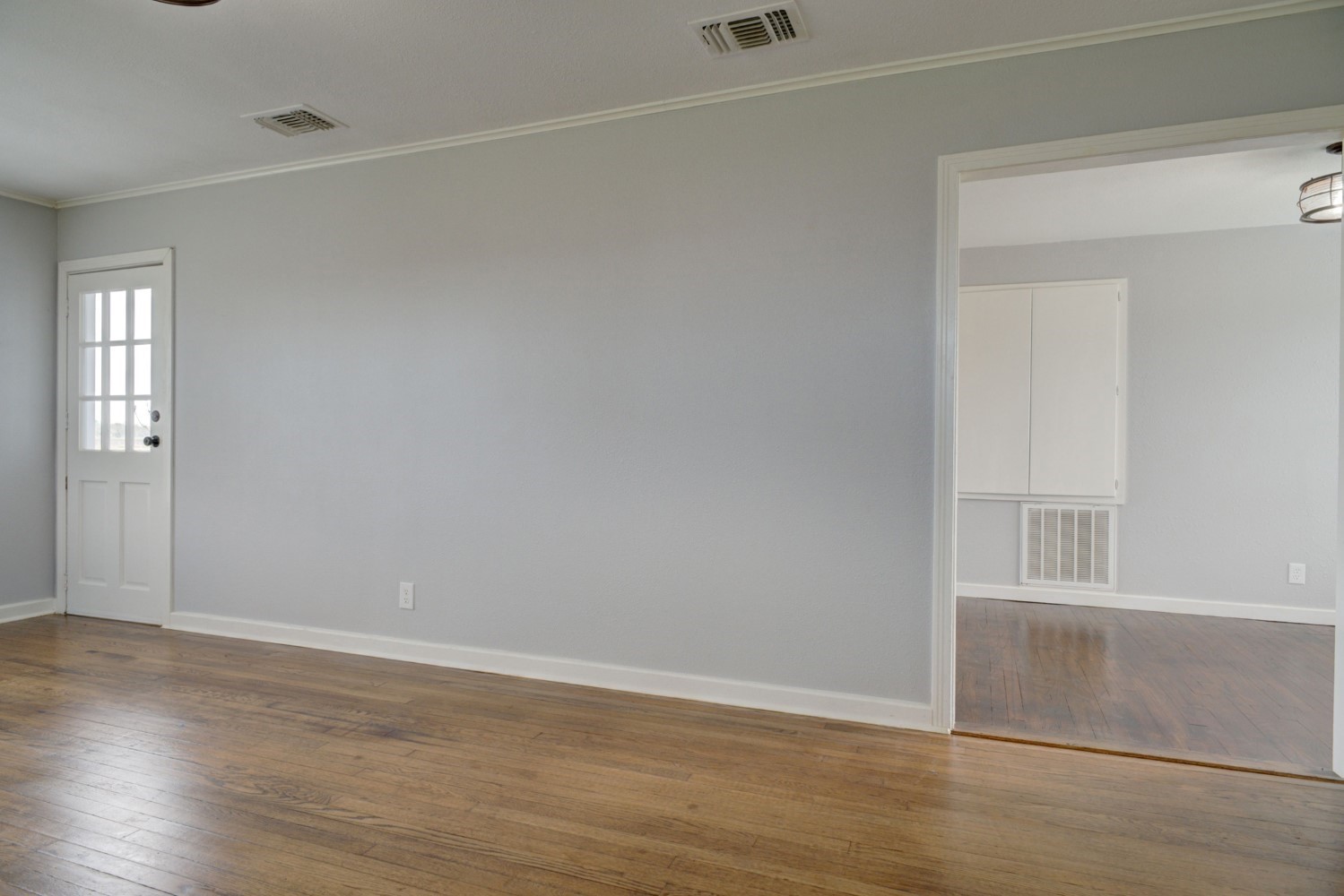 2940 Rabbs Prairie Road La Grange, TX 78945 - Photo 15 of 39 an empty room with wooden floor and windows with curtains