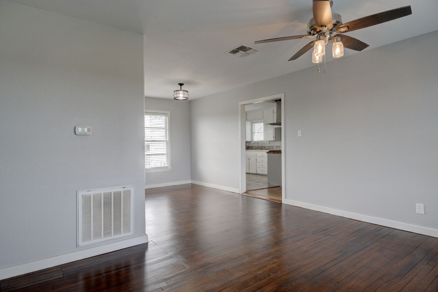 2940 Rabbs Prairie Road La Grange, TX 78945 - Photo 9 of 39 an empty room with wooden floor chandelier and windows