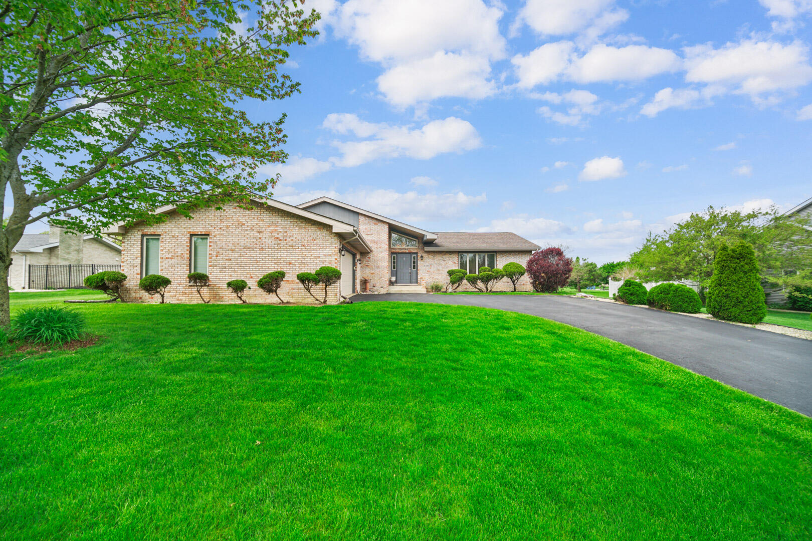 8466 Christopher Drive St. John, IN 46373 - Photo 3 of 23 a view of a white house in front of a big yard with plants and large trees