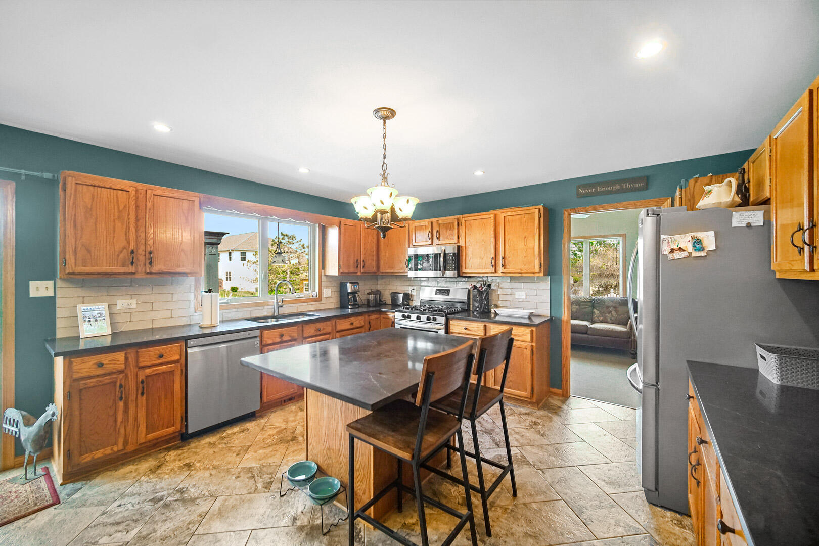8466 Christopher Drive St. John, IN 46373 - Photo 5 of 23 a dining hall with stainless steel appliances granite countertop a table chairs and a view of living room