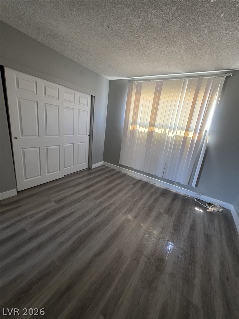 1089 East Desert Inn Road, Unit 3 Las Vegas, NV 89109 - Photo 6 of 15 Wood flooring and vertical blinds complement this inviting, well-lit room.
