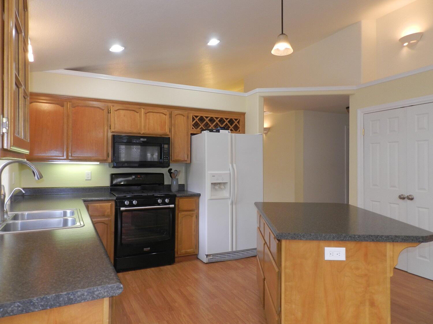 648 Benjamin Way Phoenix, OR 97535 - Photo 7 of 29 a kitchen with stainless steel appliances granite countertop a refrigerator a stove and a sink with wooden floors