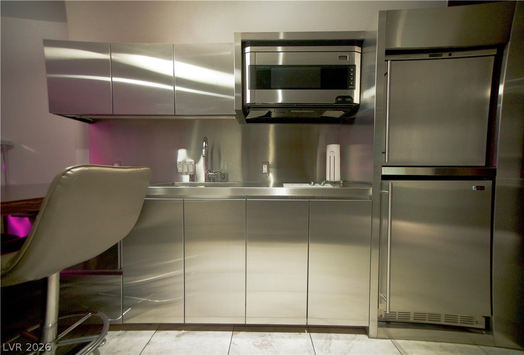 4381 West Flamingo Road, Unit 3616 Las Vegas, NV 89103 - Photo 10 of 29 A compact kitchen featuring stainless steel cabinetry and modern appliances for efficient food preparation.