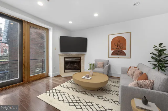 a living room with furniture a fireplace and a flat screen tv