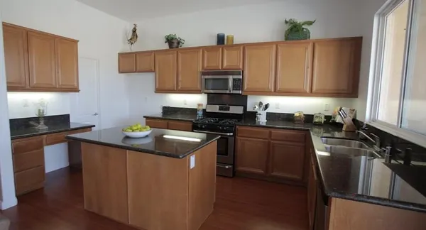 a kitchen with stainless steel appliances granite countertop a stove a sink dishwasher and a refrigerator