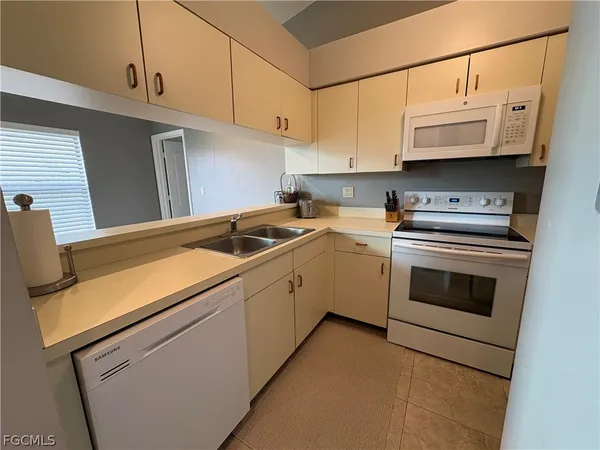 a utility room with stainless steel appliances granite countertop a sink and a stove